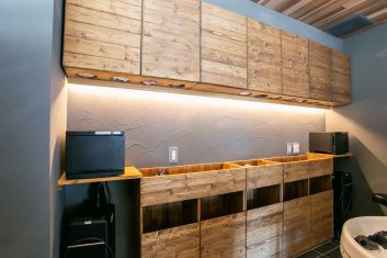 現代的な美容室の収納キャビネットとシャンプーステーション、ウォームライティングで照らされた木製デザインが特徴的