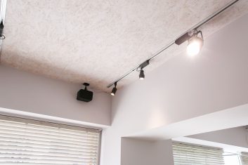 モダンな美容室のインテリア、スポットライト照明とクリーンなデザインの天井、快適な待機スペースを連想させる窓際のブラインド