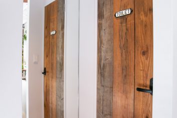 モダンなデザインの美容室内にある木製のトイレの扉、清潔で洗練されたインテリアの一部