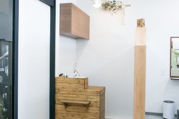 モダンで洗練された美容室の内装、白い壁と木製の家具が特徴の清潔感溢れるエントランスエリア