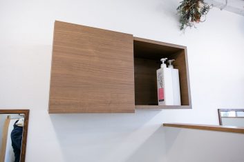 モダンな美容室の壁に取り付けられた木製の棚