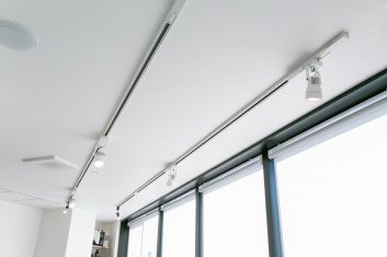 現代的な美容室の明るく清潔感のあるインテリア、天井に設置されたスポットライトと窓から自然光が差し込む空間